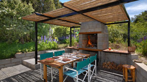 Backyard with grill under reed pergola